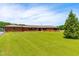 A single story brick home with a large green lawn, blue sky, and a mature evergreen tree on the right at 3187 Wilsons Mills Rd, Smithfield, NC 27577