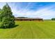 Spacious brick home featuring a well-manicured lawn in a tranquil rural setting on a beautiful sunny day at 3187 Wilsons Mills Rd, Smithfield, NC 27577