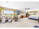 Expansive main bedroom with sitting area, large windows offering scenic views, and a ceiling fan at 3187 Wilsons Mills Rd, Smithfield, NC 27577