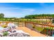 Relaxing outdoor deck with wicker seating, overlooking a pond, wooden picnic pavilion, and landscaped surroundings at 3187 Wilsons Mills Rd, Smithfield, NC 27577