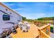 RV outdoor living space with a deck featuring wicker furniture and a view of the pond and pavilion at 3187 Wilsons Mills Rd, Smithfield, NC 27577