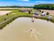 Aerial view of a tranquil pond with a fountain, dock and expansive property with lush lawns at 3187 Wilsons Mills Rd, Smithfield, NC 27577