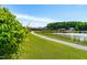 Scenic walking path leading towards a tranquil pond with a fountain and community amenities at 3187 Wilsons Mills Rd, Smithfield, NC 27577