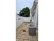 Low-maintenance stone patio in a fenced backyard with a gray exterior and a modern AC unit at 364 Bayleigh Ct, Garner, NC 27529