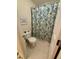Full bathroom features a vibrant paisley shower curtain, toilet, and neutral tile flooring, ideal for guests at 364 Bayleigh Ct, Garner, NC 27529