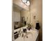 Well-lit half bathroom boasts a pedestal sink, large mirror, stylish decor, and neutral color scheme, creating a cozy space at 364 Bayleigh Ct, Garner, NC 27529