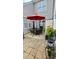 Charming outdoor patio with cast iron furniture, a red umbrella, potted plants, and a practical storage shed at 364 Bayleigh Ct, Garner, NC 27529