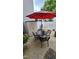 Outdoor patio featuring a dining set under a red umbrella, a storage shed, and a neatly kept privacy fence at 364 Bayleigh Ct, Garner, NC 27529
