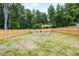 Spacious backyard with a wooden fence and stone patio with a fire pit at 389 Whetstone Dr, Angier, NC 27501