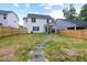 Fenced backyard featuring a well-maintained lawn and a stepping stone path leading to the house at 389 Whetstone Dr, Angier, NC 27501