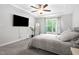 Light bedroom with a large TV, ceiling fan, and lots of natural light at 389 Whetstone Dr, Angier, NC 27501
