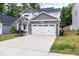Attractive home featuring a wide driveway, manicured lawn, and a stone-accented two-car garage at 389 Whetstone Dr, Angier, NC 27501