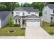Charming two-story home featuring a manicured lawn, stone accents, and a spacious two-car garage at 389 Whetstone Dr, Angier, NC 27501