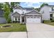 Beautiful home with a well-maintained lawn and landscaping leading to a stone-accented two-car garage at 389 Whetstone Dr, Angier, NC 27501