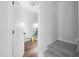 Neutral hallway with carpeted stairs, access to the upper levels of the home, and an open doorway at 389 Whetstone Dr, Angier, NC 27501