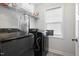 Laundry room with modern washer and dryer, shelving, and a window at 389 Whetstone Dr, Angier, NC 27501