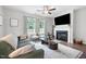 Comfortable living room with fireplace, ceiling fan, and large windows providing natural light and outdoor views at 389 Whetstone Dr, Angier, NC 27501