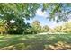View of a backyard with green grass, trees and a bench at 411 Brampton Close, Pittsboro, NC 27312