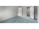 Bright bedroom featuring blue carpet, soft gray walls, and closet space at 411 Brampton Close, Pittsboro, NC 27312