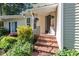 Inviting front entrance with brick steps, a black front door, and manicured landscaping at 411 Brampton Close, Pittsboro, NC 27312