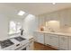 Bright kitchen with white cabinets, modern appliances, and natural light from a skylight at 411 Brampton Close, Pittsboro, NC 27312