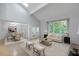 Bright living room with vaulted ceilings, large windows, and elegant furnishings creating a welcoming space at 411 Brampton Close, Pittsboro, NC 27312