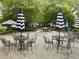 Outdoor seating area with tables, chairs, and umbrellas over a gravel surface at 411 Brampton Close, Pittsboro, NC 27312