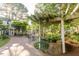 Outdoor seating area with umbrellas, surrounded by lush landscaping and a tranquil pond at 411 Brampton Close, Pittsboro, NC 27312