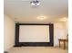 Finished basement with large projector screen, neutral carpet, and door to exterior at 4355 Pond Pine Trl, Morrisville, NC 27560