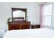 Well-lit bedroom featuring a dresser with a large mirror and coordinated decor, bathed in natural light at 4355 Pond Pine Trl, Morrisville, NC 27560