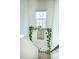 Bright stairway with a window, artwork, and decorative vines adding a touch of nature at 4355 Pond Pine Trl, Morrisville, NC 27560