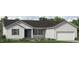 Single-story home featuring light siding, dark shutters and a front door with lovely landscaping and an attached garage at 4451 Poppy Mallow Ln, Oxford, NC 27565