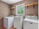 Laundry room with tile floors, washer, dryer, utility sink, and wooden shelves at 4508 Old Us 421 N N, Siler City, NC 27344