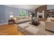 Staged living room featuring hardwood floors, a brick fireplace, a comfortable sofa, and ample natural light at 4508 Old Us 421 N N, Siler City, NC 27344