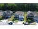 Aerial view of three houses featuring a well-manicured lawn, driveway, and beautiful trees at 4907 Sleepy Falls, Knightdale, NC 27545