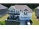Two story home with attached garage, neutral siding, front porch, dark shutters and lush landscaping at 4907 Sleepy Falls, Knightdale, NC 27545