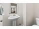 Well-lit powder room with a pedestal sink, tile floor and mirror at 4907 Sleepy Falls Run, Knightdale, NC 27545
