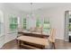 Bright dining area with a chandelier and table set with a bench and chairs overlooking the backyard at 4907 Sleepy Falls Run, Knightdale, NC 27545