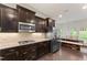 Well-lit kitchen featuring stainless steel appliances, dark wood cabinets, and granite countertops at 4907 Sleepy Falls Run, Knightdale, NC 27545