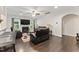 Elegant living room with fireplace, a ceiling fan, and dark hardwood floors, creating a cozy ambiance at 4907 Sleepy Falls Run, Knightdale, NC 27545