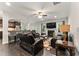 Spacious living room with dark wood floors, comfortable leather seating, fireplace and open kitchen at 4907 Sleepy Falls Run, Knightdale, NC 27545