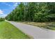 Picturesque street view with a paved road surrounded by lush trees and manicured lawns at 4907 Sleepy Falls Run, Knightdale, NC 27545