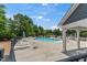 Resort-style swimming pool area with white lounge chairs, umbrellas, and covered seating, a perfect relaxation spot at 4907 Sleepy Falls Run, Knightdale, NC 27545
