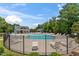 Outdoor swimming pool surrounded by lounge chairs, umbrellas, and a fence, within a landscaped community space at 4907 Sleepy Falls Run, Knightdale, NC 27545