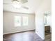 Bright bedroom featuring hardwood floors, two windows, and an en suite bathroom at 5505 Pennfine Dr, Raleigh, NC 27610