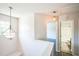 Bright hallway featuring a modern chandelier, neutral walls, and access to the bathroom at 5505 Pennfine Dr, Raleigh, NC 27610