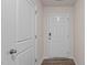 Bright entryway featuring a white front door, light walls, and wood-look flooring; next to a closed interior door at 552 Stream Walk Xing, Wendell, NC 27591