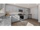 Well-lit kitchen featuring modern grey cabinetry, granite countertops, and stainless steel appliances for a sleek design at 552 Stream Walk Xing, Wendell, NC 27591
