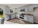 Modern kitchen featuring grey cabinets, granite counters, and stainless steel appliances, illuminated by recessed lighting at 552 Stream Walk Xing, Wendell, NC 27591