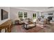 Open concept living room with large windows, a decorative rug, and seamless transition to the dining area and kitchen at 552 Stream Walk Xing, Wendell, NC 27591
